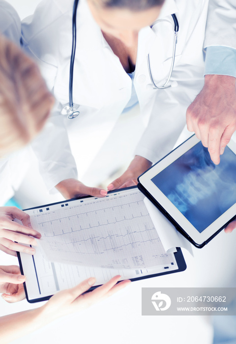 group of doctors looking at x-ray on tablet pc