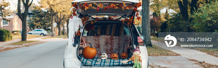 Trick o trunk. White car trunk decorated for Halloween. Autumn fall decor with red pumpkins and yell