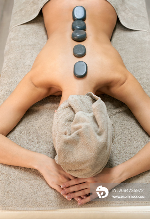 Woman in spa salon having hot stone massage