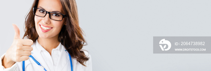 Female doctor with thumbs up gesture, over grey