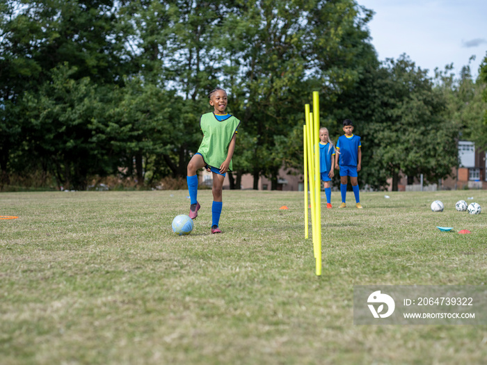 身着制服的儿童（8-9岁）在足球场上练习