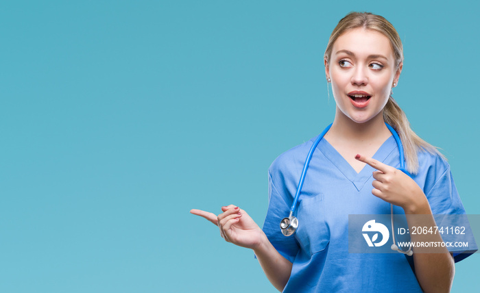 Young blonde surgeon doctor woman over isolated background amazed and smiling to the camera while pr