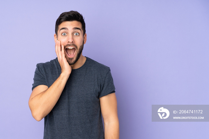 Caucasian handsome man with surprise and shocked facial expression over isolated purple background