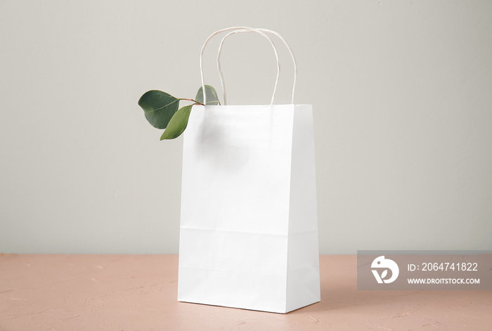 Paper bag on table against light background