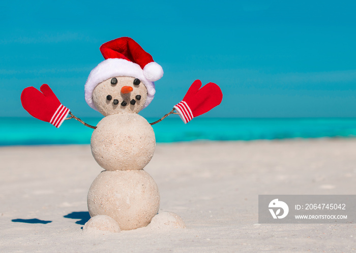 Sandy Christmas snowman in red Santa hat and mittens without sunglasses. Beach Snowman. Happy Smiley