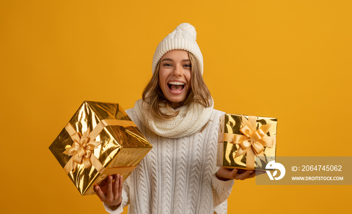 年轻、微笑、快乐、漂亮的女人，手里拿着金色的礼盒庆祝新年、圣诞礼物，