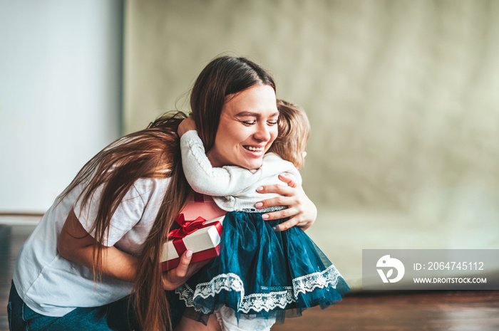 Mom hugs her baby daughter and is happy with the gift