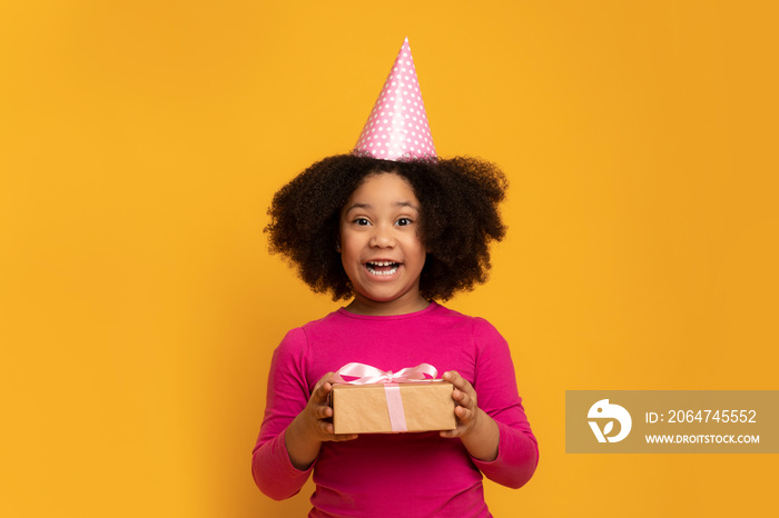 快乐的非洲生日小女孩戴着派对帽拿着礼物