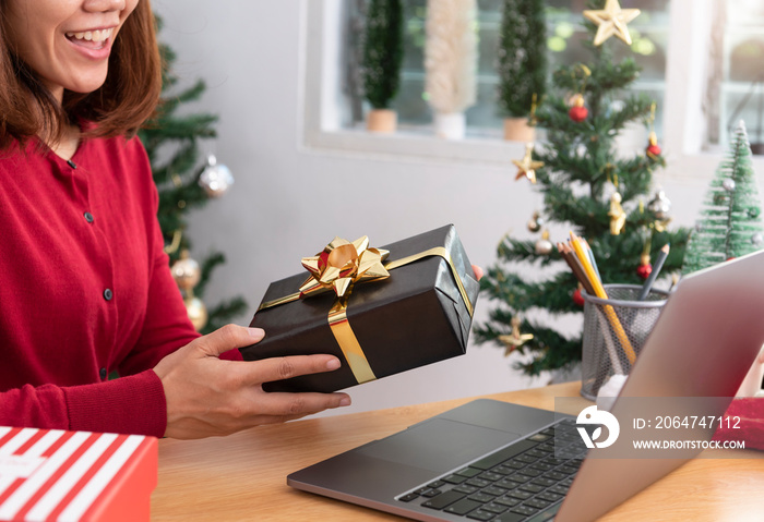 business woman holding giftbox on office table in Christmas day.