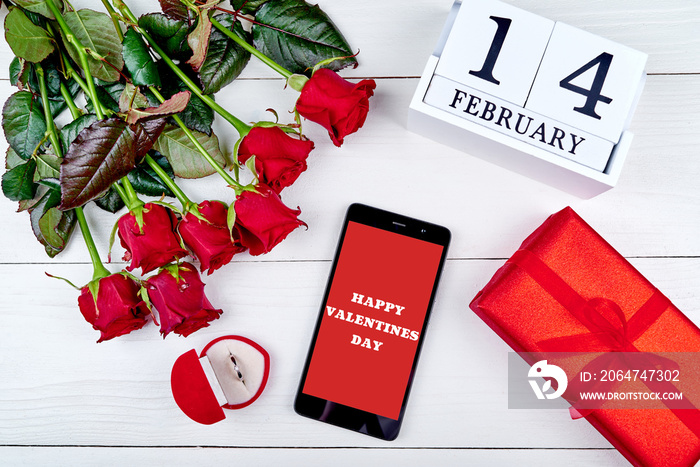 Bouquet of red roses, cellphone with sign Happy Valentines day, diamond ring, gift box and february 