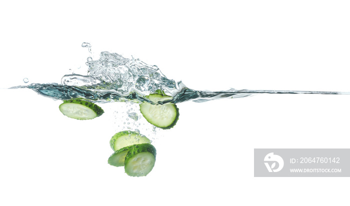 Falling of fresh cut cucumber into water against white background