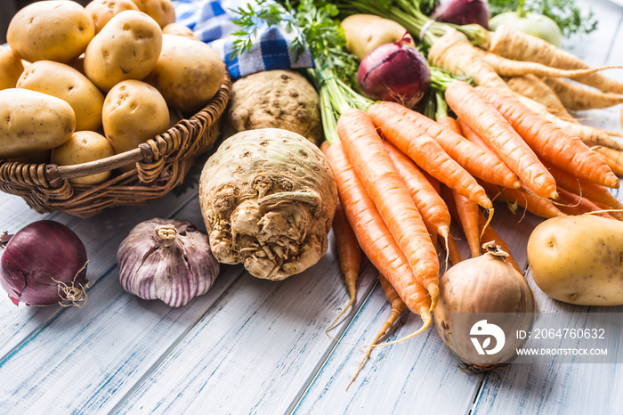 Assortment of fresh vegetables on wooden table. Carrot parsnip garlic celery onion and kohlrabi