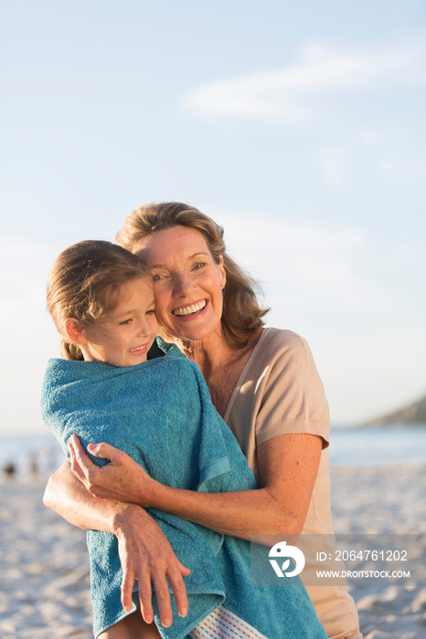 Portrait happy grandmother and granddaughter on sunny beach