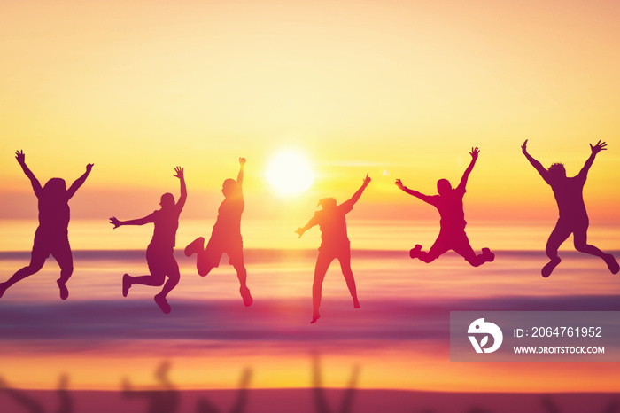 Happy friend jumping at tropical sunset beach background.