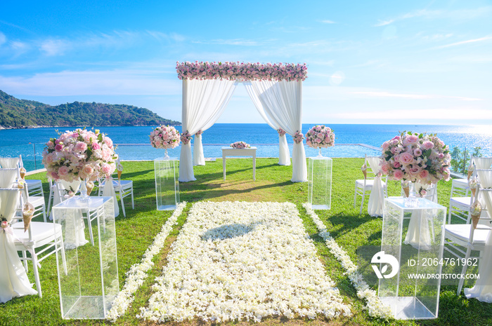 婚礼。拱门，草坪上装饰着鲜花，海滩背景，夏天的大海。