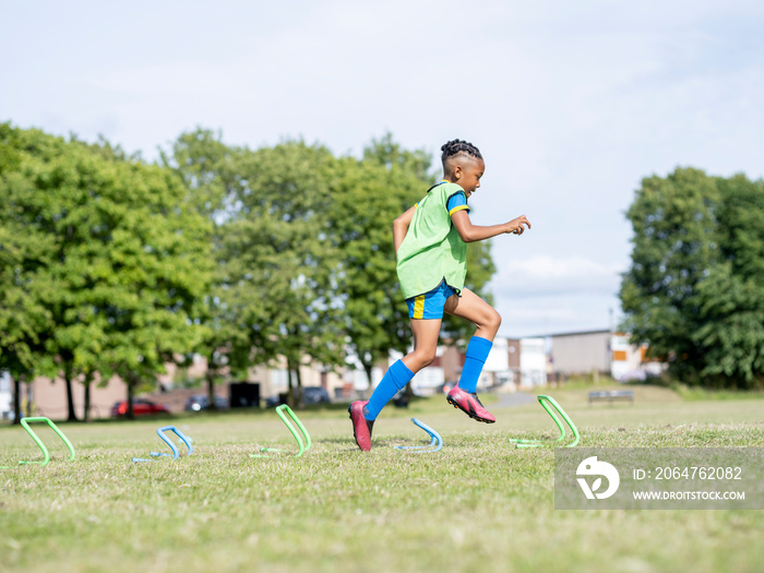 男孩（8-9岁）穿着制服在足球场上练习