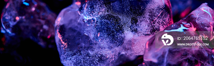 透明冰块全景拍摄，紫色彩色照明隔离在黑色上