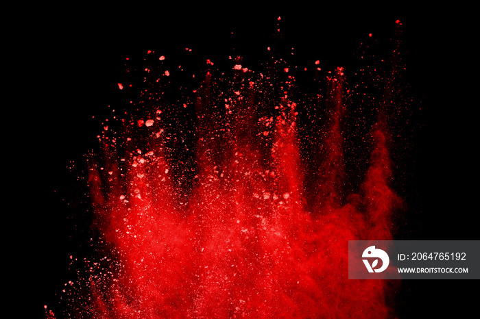 Red powder explosion isolated on black background.