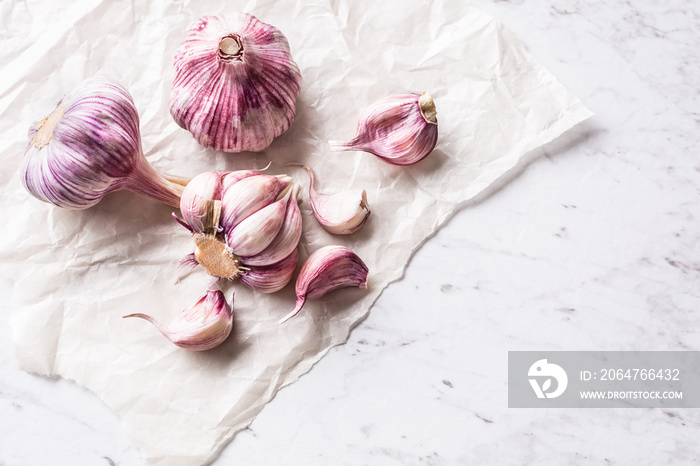 Garlic Cloves and Bulbs on white marble board