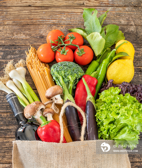 Many vegetables and fruits in the shopping bag on the table