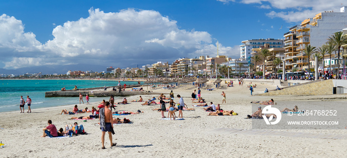 人们在西班牙巴列雷斯马略卡岛El Arenal度假小镇的海滩上晒日光浴