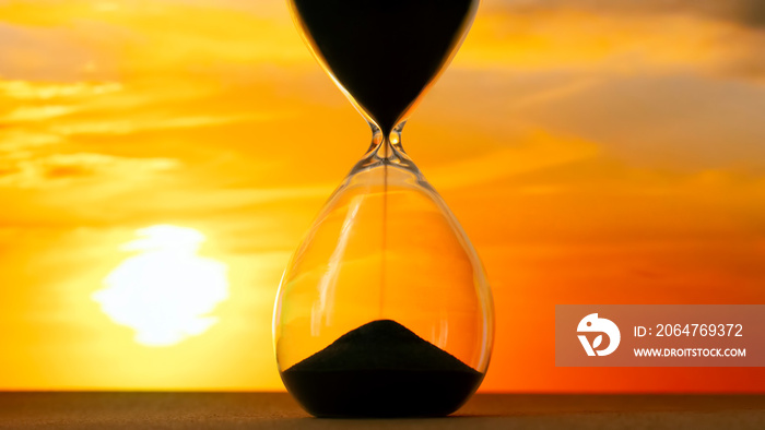 Hourglass on the background of a sunset. The value of time in life. An eternity.