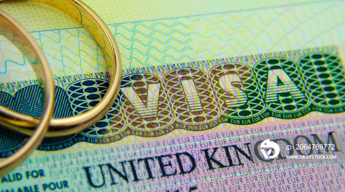 护照上的英国入境签证贴纸和顶部的戒指。伴侣和配偶签证的概念