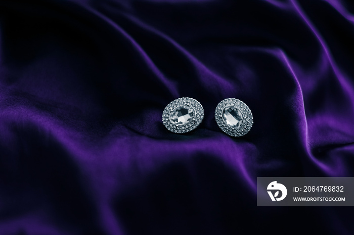 深紫色丝绸面料的奢华钻石耳环，节日魅力珠宝礼物