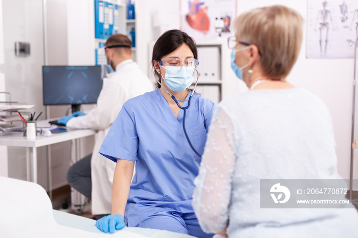 Nurse consulting senior patinet heart during health check up during covid19 outbreak. Medical specia