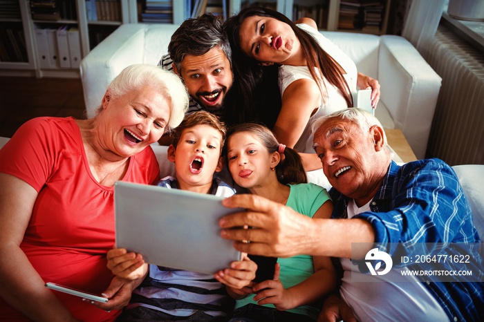 Multi generation family taking a selfie on digital tablet in