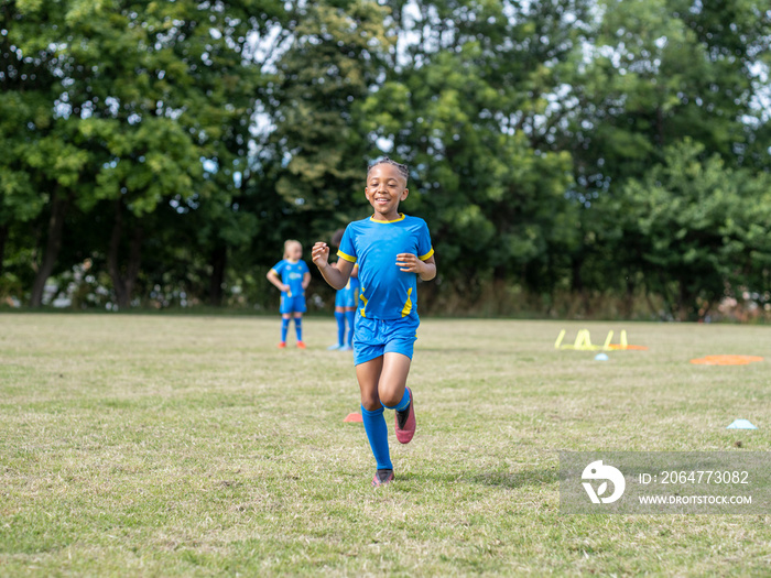 穿着制服在足球场上练习的儿童（8-9岁）