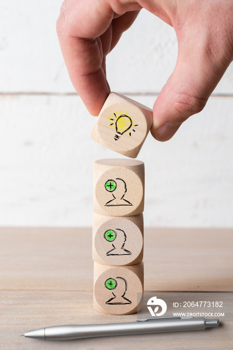 many people together having an idea symbolized by icons on cubes on wooden background