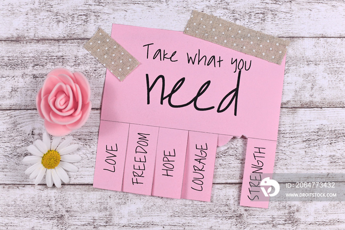 Pink tear-off stub note with text Take what you need and words Love, Freedom, Hope, Courage and 