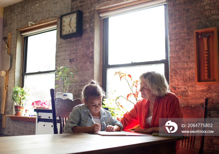 Grandmother doing homework with girl (6-7)