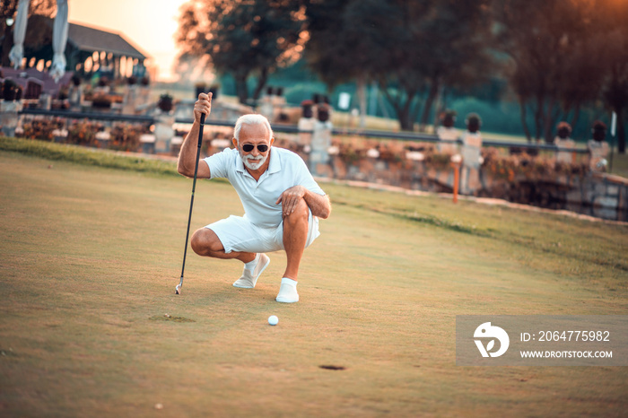 Senior man playing golf alone.