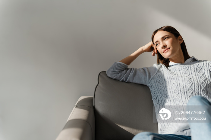 Smiling middle aged woman relaxing on a couch