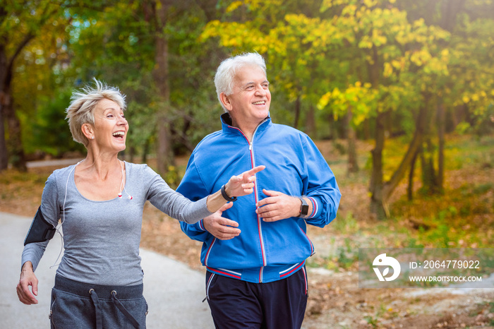 微笑的老年活跃夫妇一起在公园慢跑