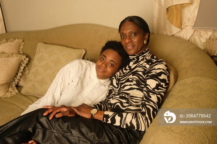 Mother and daughter sitting on couch