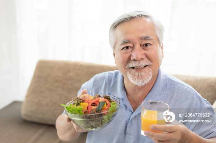 生活方式老年人在沙发上享受减肥食品新鲜沙拉和橙汁的乐趣