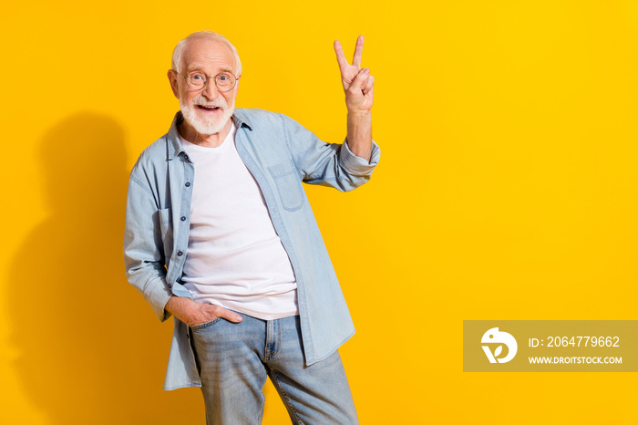 Portrait of attractive funky cheerful grey-haired man showing v-sign good mood isolated over bright 