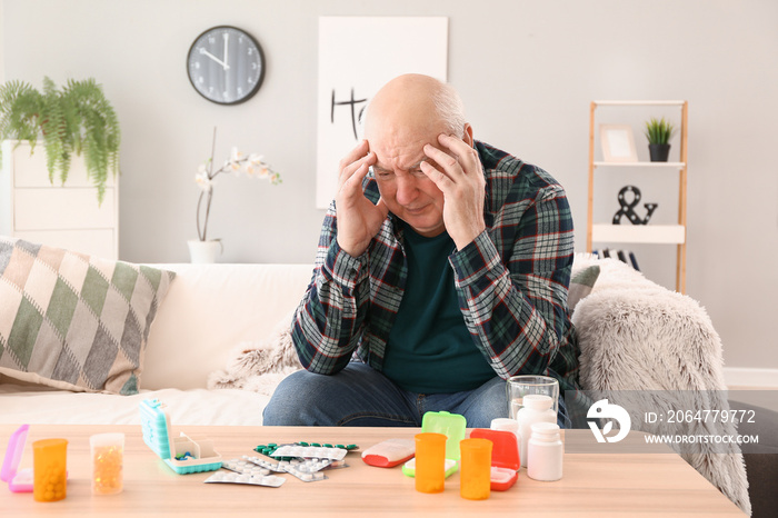 Elderly man with pills at home