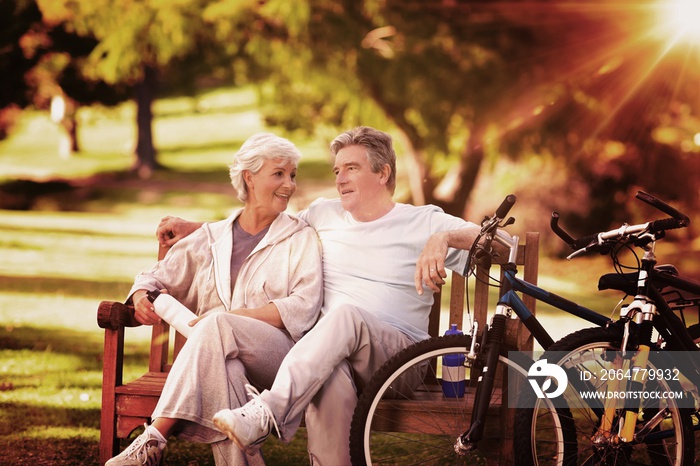 Composite image of elderly couple with their bikes