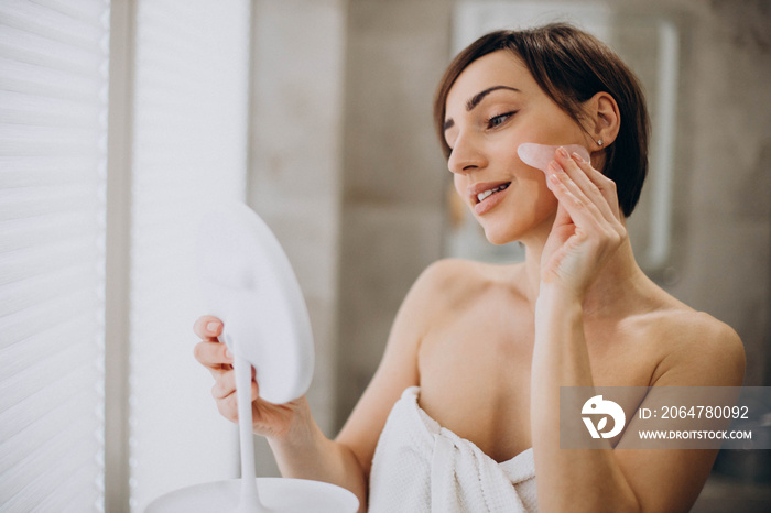 Woman using gua sha stone at spa