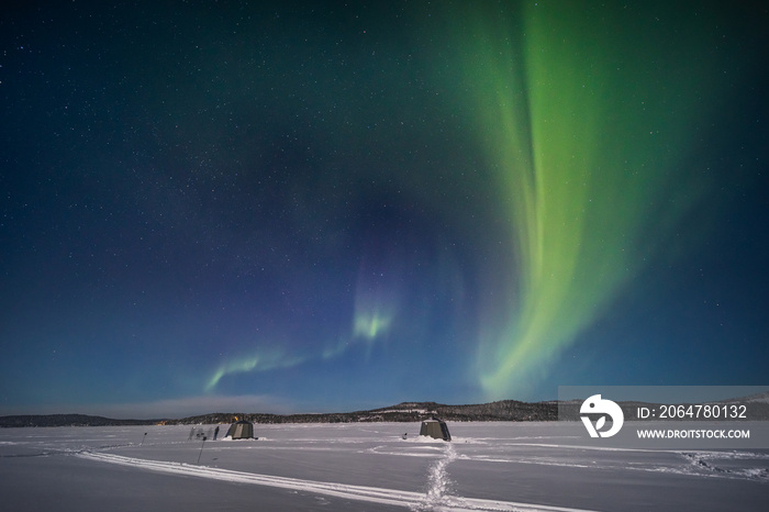 The northern lights over a frozen river in Swedish Lapland