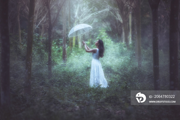 一个拿着白伞的女孩站在森林里。