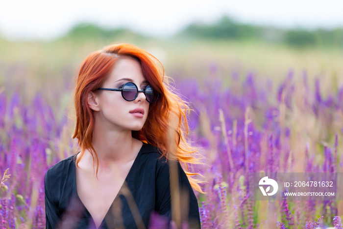 beautiful young woman sitting and relaxing on the wonderful blooming lavender field