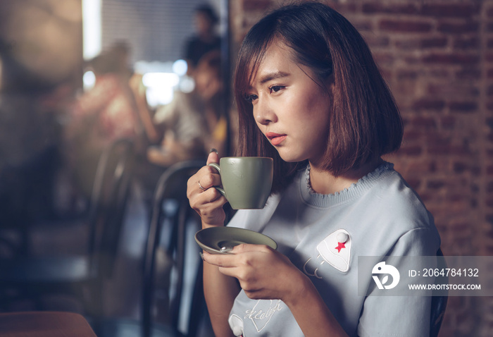 美丽的年轻亚洲女人在咖啡馆餐厅喝咖啡