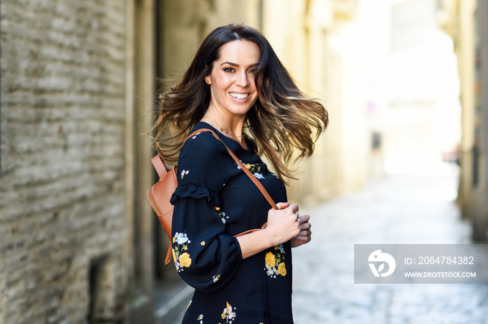 Young woman moving her long hair in urban background.