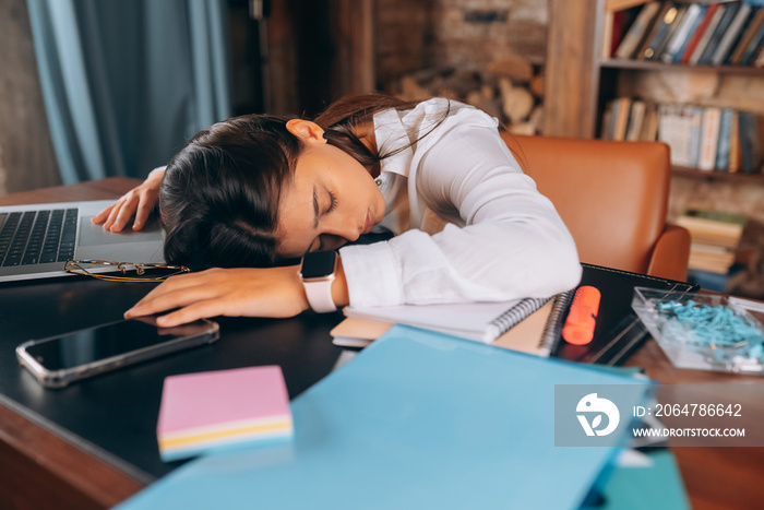 Young beautiful woman fell asleep at her desk