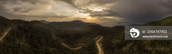 Remote mountain road surrounded in thick forest at sunset, Fethiye, Turkey